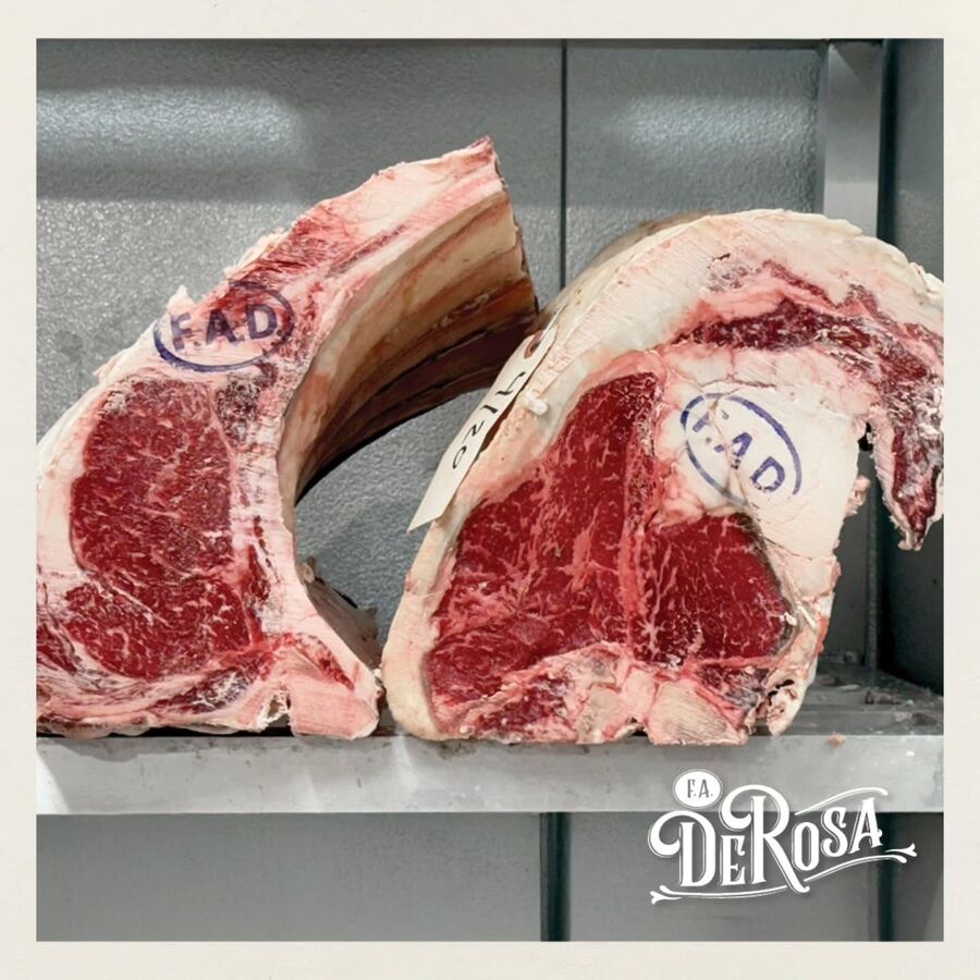 Two USDA Prime rib primals in the cooler, each stamped F.A.D. and tagged with its aging date