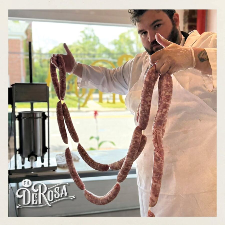 Fresh Italian sausage being hand-cased in the shop